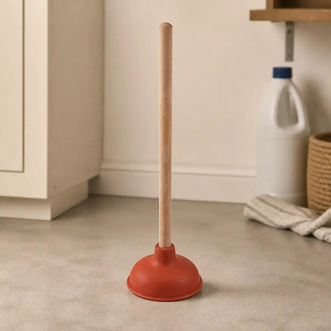Six Inch Red Rubber Plunger With Sturdy Wood Handle Built For Light Duty Bathroom Drain And Toilet Jobs That Knock Out Stubborn Clogs Without Any Drama on a kitchen floor.