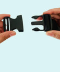 Hands displaying black One Point Five Inch Quick Side Release Buckles Eight Pack Go To Heavy Duty Plastic Buckles for webbing.