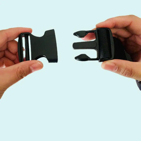 Hands displaying black One Point Five Inch Quick Side Release Buckles Eight Pack Go To Heavy Duty Plastic Buckles for webbing.