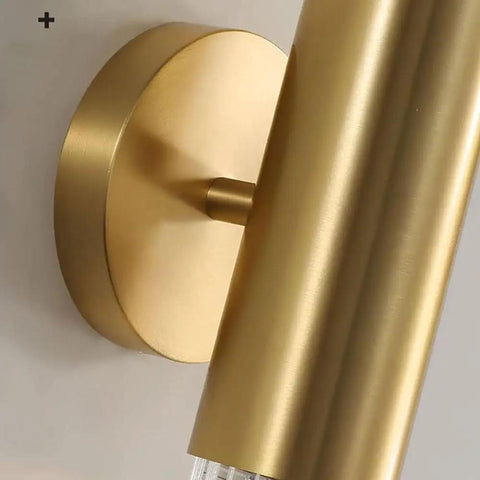 Close-up of wall sconce light features brushed brass mount and copper finish, suitable for bedroom or hallway.