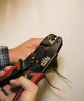 Hands using Pro-Grade Wire Stripper And Ratcheting Crimper Kit For Insulated Terminals on electrical wiring.