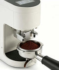 Automatic Electric Coffee Tamper With LCD Screen And Adjustable Pressure showing espresso grounds in steel portafilter.