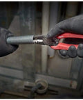Gloved hands using Six-In-One Long Nose Pliers For Electricians Pro Grade Wire Stripper And Reamer Combo Seven And One Half Inch Forged Alloy Steel