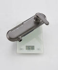 Piano Key Shower System Wall Mounted Exposed Gun Gray 3 in 1 valve body on a scale, showcasing its weight and design.