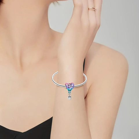 Hot Air Balloon Happy Birthday Dangle Charm In 925 Sterling Silver With Pink Purple And Blue Enamel on a woman's wrist