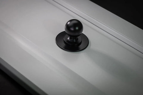 Matte Black Cabinet Knobs Four Pack With Wide Backplates installed on a white cabinet door, large ball knob visible