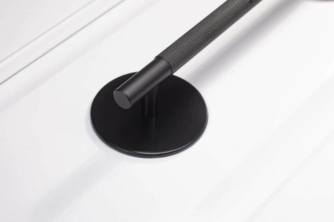 Close-up of a Matte Black Escutcheon Back Plate For Cabinet Knobs And Doors, installed with a handle, showing the round rosette plate.