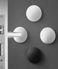 Three Piece Wall Doorstop Set with Self Adhesive Silicone Bumper Pads next to a door handle, shown in use protecting a wall.