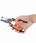 Hand holding versatile wire stripper pliers cutting tool for DIY wiring auto and home projects electrician grade heavy duty manganese alloy built
