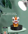 JAYEGT 22lbs Motorized Rotating Turntable Display Stand showcasing colorful lion figure with smartphone on a black display base.