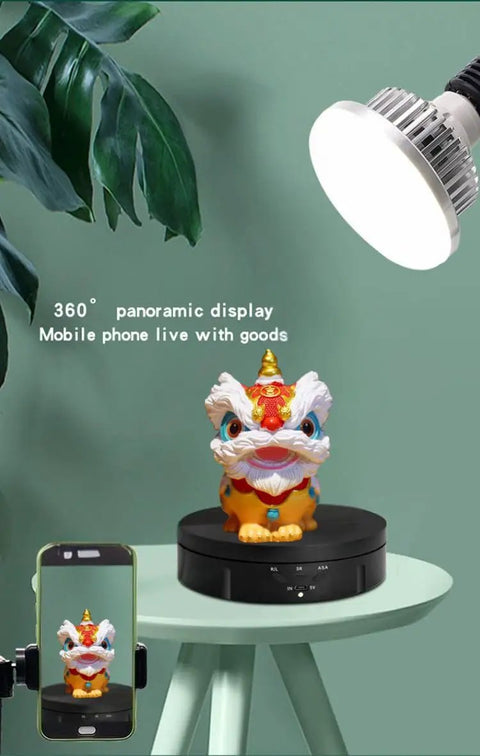 JAYEGT 22lbs Motorized Rotating Turntable Display Stand showcasing colorful lion figure with smartphone on a black display base.