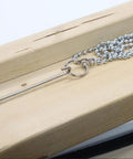 Stainless steel fish ball chain with stop ring on wood, part of Fish Ball Chain 16 Feet With 2 Stop Rings For Hidden Wiring In Narrow Or Inaccessible Wall Spaces.