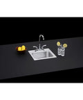 Drop-In 15x15 Inch Single Bowl Stainless Steel Bar Sink With Faucet Kit installed in a modern countertop setup with lemons and glass.