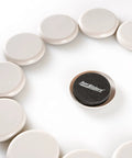 Round Two And Half Inch Reusable Furniture Sliders For Carpet Eight Pack Beige arranged in circle with one flipped showing black surface.