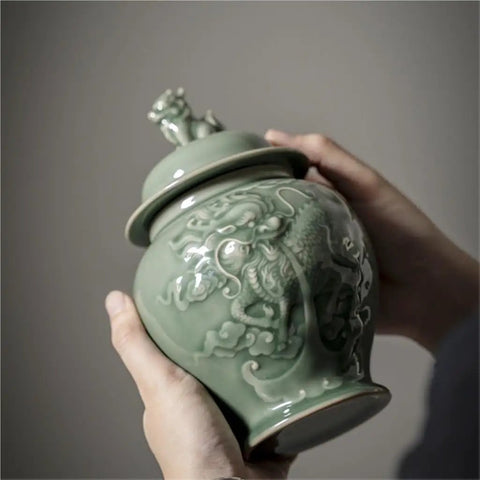 Top Tier Ceramic Airtight Tea Canisters For Loose Tea Leaves And Coffee Beans Hand Embossed Celadon Kirin Design in hand.