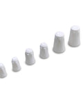 Six white ceramic wire caps arranged diagonally in ascending sizes (side view)