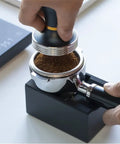 Solid Kickass Coffee Tamping Station With Integrated Espresso Scale Base, tamping coffee grounds in portafilter.