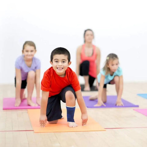 Child wearing a kids compression ankle sleeve for sprains and tendonitis knitted ankle brace during a yoga class with others