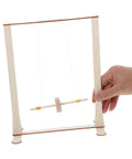 Hand holding Educational Wooden Gravity Experiment Kit For Kids And Students, Interactive Maxwell Wheel Science Toy.