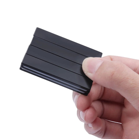 Neodymium bar magnet, epoxy-coated, black, 60 x 10 x 3 mm, close-up held in hand