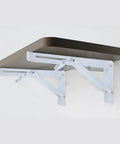 Rock Solid White Folding Shelf Brackets Built Like A Truck Wall Mounted supports a brown shelf, heavy duty steel, measures 8x7 inches.