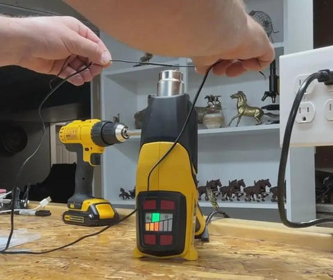 Person using a heat gun for Top Shelf Heavy Duty Adhesive Lined Heat Shrink Tubing Kit with wiring prep.