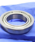 Get A Cool 10 Pack Of F6802ZZ Flanged Ball Bearings Featuring Double Shields And Deep Groove Design Perfect For Industrial Projects With 15Mm 24Mm 5mm Dimensions That Rock Your Machine Setup close-up view of a F6802ZZ bearing on blue glove.