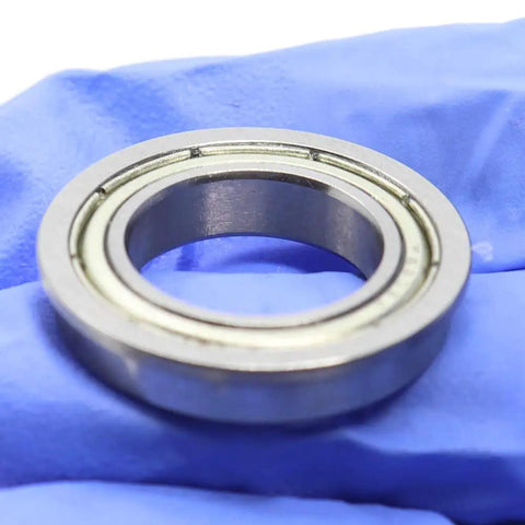 Get A Cool 10 Pack Of F6802ZZ Flanged Ball Bearings Featuring Double Shields And Deep Groove Design Perfect For Industrial Projects With 15Mm 24Mm 5mm Dimensions That Rock Your Machine Setup close-up view of a F6802ZZ bearing on blue glove.