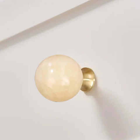 Slick Modern Brush Brass Crystal Round Ball Knobs For Dresser Drawers And Vanity Cabinets With 1 1/4 Inch Diameter, featuring a shiny yellow jade accent.