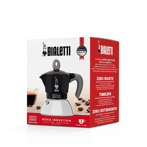 Heavy Duty Moka Induction Coffee Maker With Rock Solid Stainless Steel Boiler And Premium Aluminum Lid Brews Smooth Two Cup Espresso That Nails Your Morning Kickstart In Deep Black displayed in packaging.