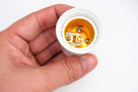 Hand holding a 4 Pack E26 E27 Lamp Socket Adapter Converts Outlet To Dual E26 Light Sockets For Lamps And Fixtures, view of socket interior
