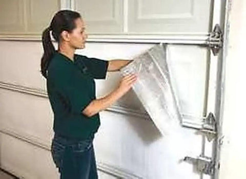 Woman installing Kickass Reflective Foam Core Insulation Roll With Radiant Barrier And Vapor Block on a garage door.