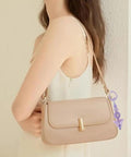 Woman wearing a beige purse with a 14 Color Spring Gate Ring Set For Keychains And Craft Projects attached to the strap.