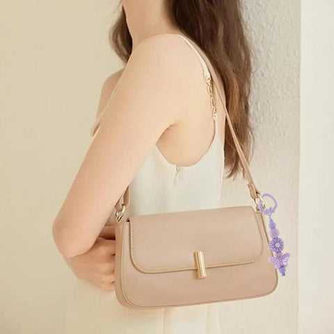 Woman wearing a beige purse with a 14 Color Spring Gate Ring Set For Keychains And Craft Projects attached to the strap.