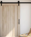 Wooden sliding barn door with matte black handle and track in modern interior