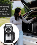 Front view of Baby Brezza Formula Pro Mini travel bag with bottle maker inside; black bag by open car trunk