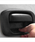 Close-up installed tailgate handle bezel cover, black textured plastic, rear exterior for 1999-2007 Silverado/Sierra