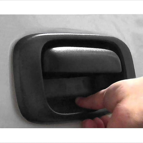Close-up installed tailgate handle bezel cover, black textured plastic, rear exterior for 1999-2007 Silverado/Sierra