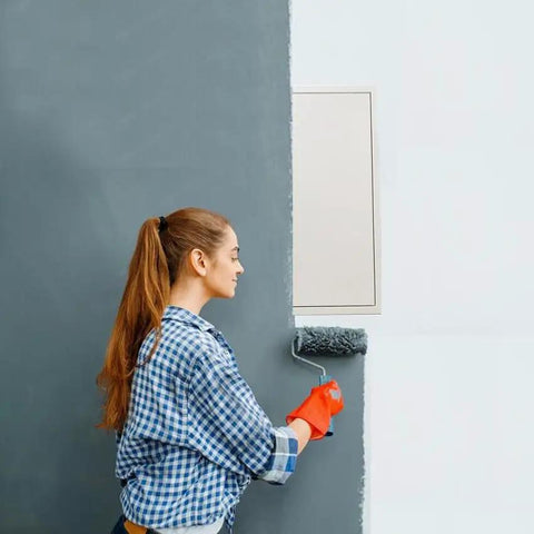 Woman painting a wall near a Heavy Duty Metal Access Panel 18 X 24 Inch Spring Loaded Drywall Cover Touch Latch No Key Needed.