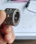 iDili Electric Mini Internal Chamfering Tool Deburring Machine With Diamond Grinding Head For Tiny Holes 1.5mm showing a metallic part with holes held in a hand.
