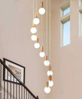 Top Shelf Three Head Disc Pendant Ceiling Light With Milky Frosted Glass Lampshades And Heavy Duty Wrought Iron Frame hanging in a stairwell.