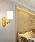 Solid Brass Wall Sconce With Smooth White Glass Shade Modern E27 Light Fixture mounted by a cozy bedroom wall.