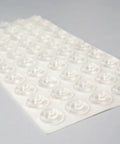 Sheet of sound dampening door bumpers, half inch dia, 5mm height, soft durometer, clear adhesive, 100 count, angled view