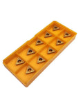 Angled top view of yellow plastic organizer with 12 TCMT-style carbide turning inserts.