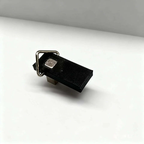 Magnetic hold-down clamp for honeycomb work tables; black rectangular body with metal ring and magnet plate.