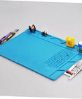 Top Notch Silicone Repair Mat With Heat Resistant Non Slip Surface And Precision Pin Layout For Soldering Stations Laminating Machines And No Sweat Tech Fixes with tools and components arranged.