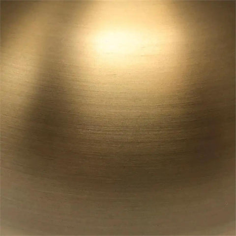 Close-up view of the brushed brass finish of the 27 Inch Tall Arc Table Lamp With Seeded Glass Shade In Brushed Brass Finish For Home Or Office Desk Reading And Task Lighting Ideal For Nightstands And Side Tables A Classic Yet Modern Accent Lamp For Your Setup.