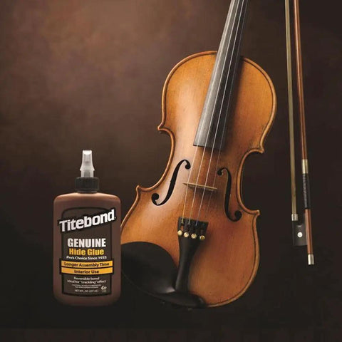 Top Tier Liquid Hide Glue For Fine Woodworking And Furniture Restoration Quick Setting Reversible Adhesive 8 Ounce Bottle next to a violin.