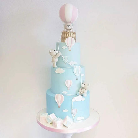 Blue cake decorated with hot air balloon and cloud designs using 13 Piece Hot Air Balloon and Cloud Fondant Cutter Set for Cakes.