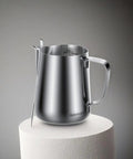 20oz Stainless Steel Milk Frothing Pitcher With Latte Art Pen For Home Espresso Machines And Coffee Bars on a pedestal